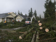 A crew from Battle Ground Public Works clears the aftermath of a tornado that tore through the city at about 11:15 a.m. Thursday, uprooting trees and damaging homes and power lines.