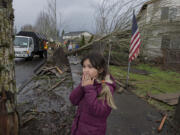 Battle Ground resident Bela Morgan, 9, reacts to seeing damage and debris left by a tornado along Southeast Rasmussen Boulevard. She viewed the aftermath, including a knife stuck in a tree, Thursday afternoon with her family.