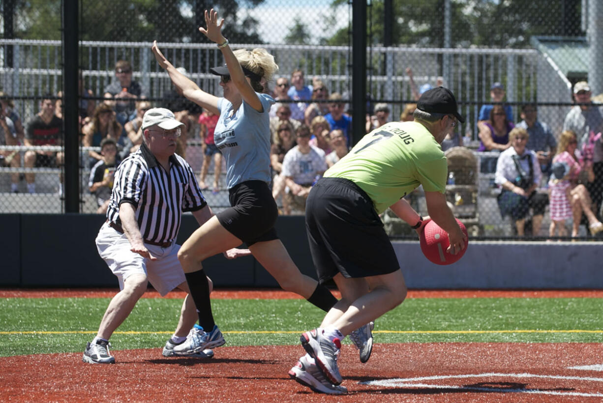 Clark County Sheriff Garry Lucas calls base runner Michele Rudi safe as Doug Ballou misses the tag during a celebrity kickball game Saturday at Luke Jensen Sports Park.