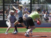 Clark County Sheriff Garry Lucas calls base runner Michele Rudi safe as Doug Ballou misses the tag during a celebrity kickball game Saturday at Luke Jensen Sports Park.