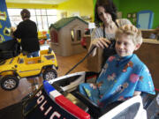 Photos by Steven Lane/The Columbian
Thomas Doerfler, 7, gets his hair cut by stylist Alli Bessette. This was Thomas' sixth haircut at the Lil' Snippers Hair Care 4 Kids and he always sits in the police car.