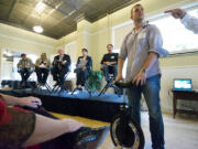 David Martschinske, chief operations officer of Focus Designs in Camas, right, answers questions about his self-balancing unicycle during a PubTalk event at the Fort Vancouver Artillery Barracks on Tuesday.