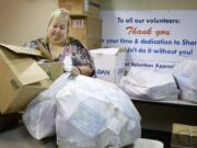 Susan Oberst, director of volunteers and community resources at Share, moves donations from a meeting room earlier this month. &quot;I do love my volunteers,&quot; she said.