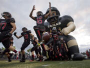 The Camas High School football team takes the field for the first game of the season against Jesuit High School.