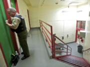 Clark County Sheriff's Custody Officer Jeff Young talks to a female inmate while giving a tour of D pod in the Clark County Jail.