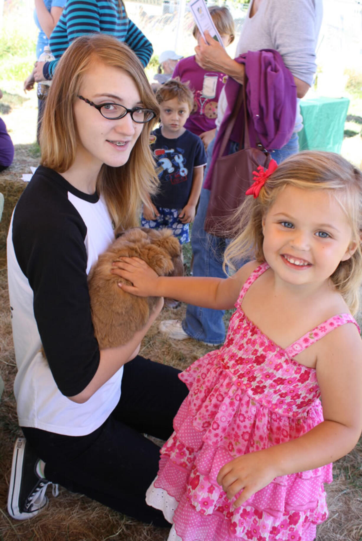 Lizi Jesser, 15, from Country Critters 4-H Club, left, shows Rusty, her Holland lop rabbit, to Serenity Bury, 3, at the Harvest Fun Day Sept.