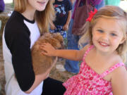 Lizi Jesser, 15, from Country Critters 4-H Club, left, shows Rusty, her Holland lop rabbit, to Serenity Bury, 3, at the Harvest Fun Day Sept.