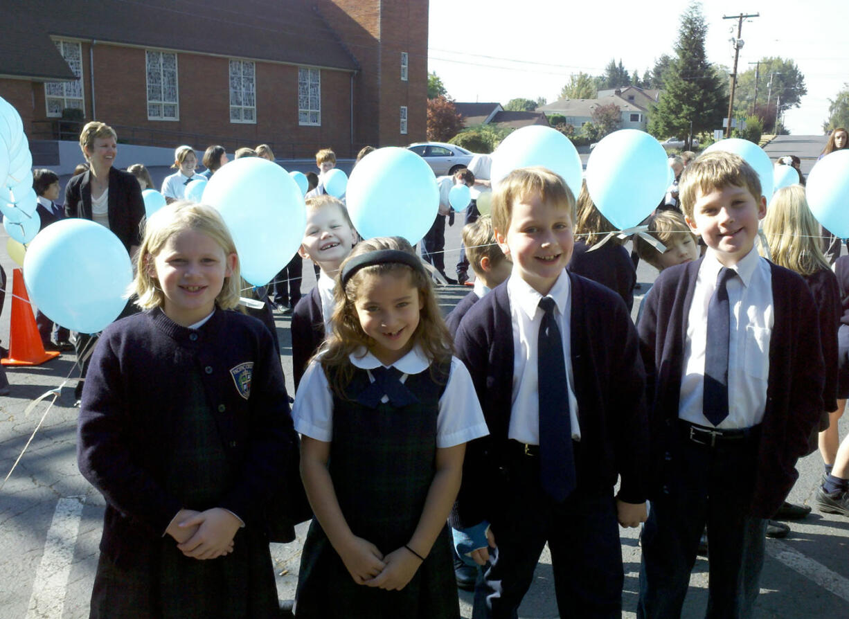 Camas: Pacific Crest Academy third graders Avery Deringer, left, Bella Groff, David Marshall and Christopher Spencer were among the students who tied their prayer intentions onto a giant Rosary made of balloons on Oct.