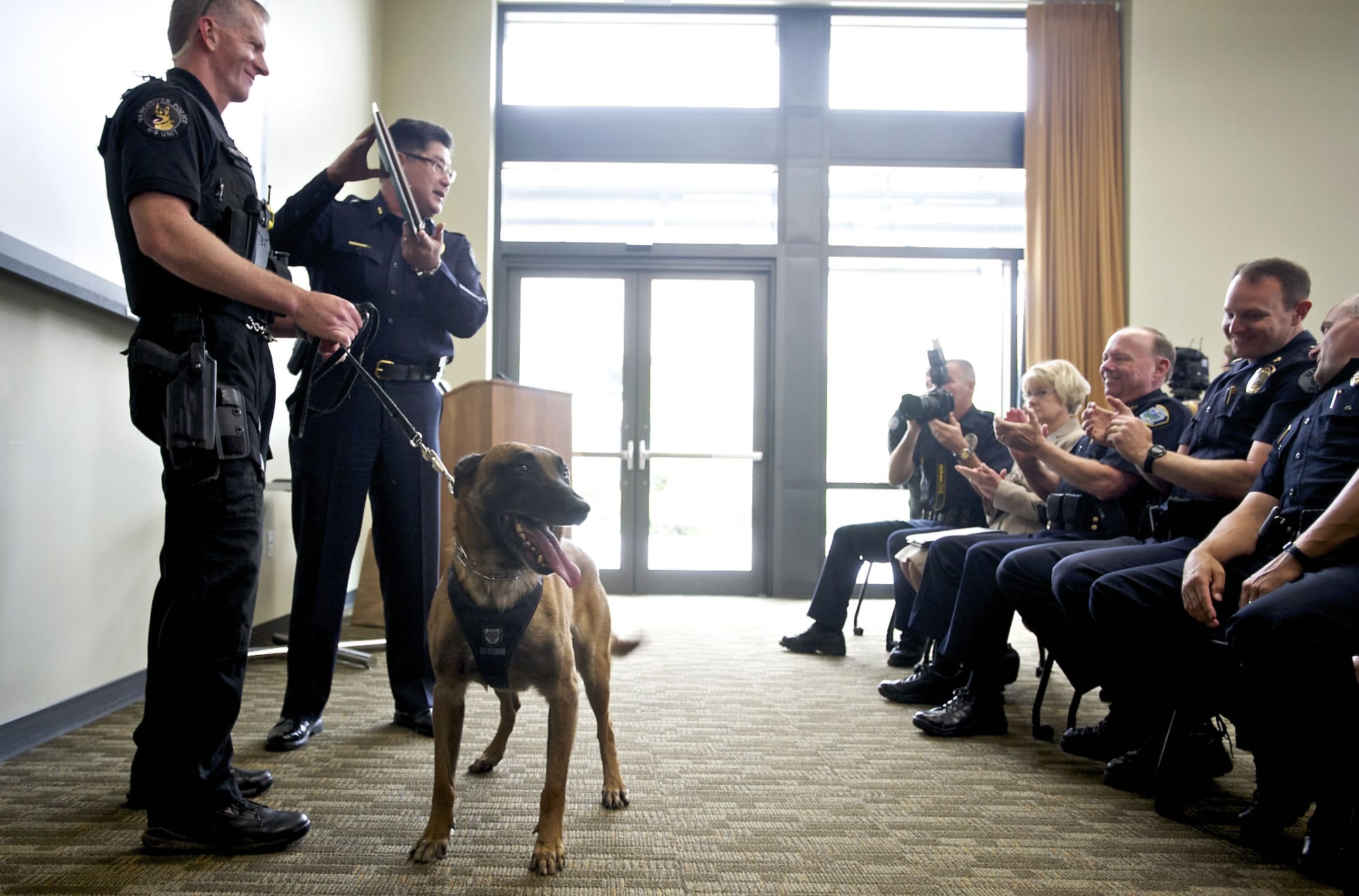 Vancouver Police Chief Cliff Cook presents Officer Jack Anderson, left, and his new canine partner, Ike, with a plaque to recognize their recent completion of certification training.