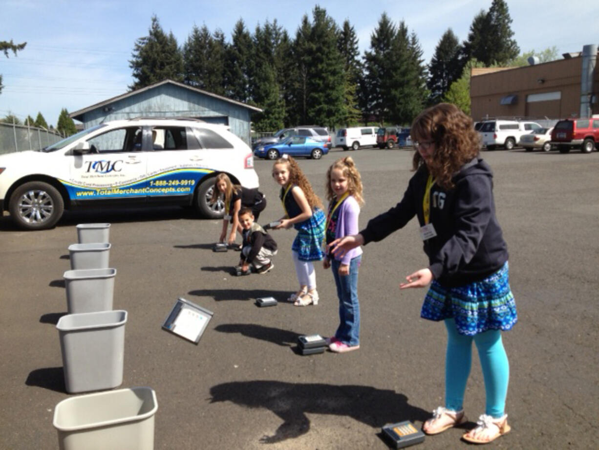 Orchards: Children of employees at Total Merchant Concepts play a game of tossing out broken machinery during Take Your Child to Work Day on April 25.