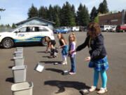 Orchards: Children of employees at Total Merchant Concepts play a game of tossing out broken machinery during Take Your Child to Work Day on April 25.