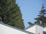 A sheriff's deputy keeps watch as a firefighter checks for hot spots the roof early into the four-hour standoff with Angel M.