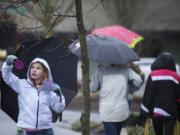 Hough student Lucy Maddux, 10, hangs an ornament that reads &quot;love you&quot; from a tree in front of Compass Church as the Junior Joy Team spread positive messages along Main Street on Thursday morning.