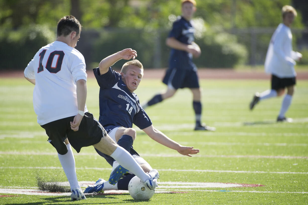 Carter Johnson, 14, of Skyview High School slide tackles Cameron Watson, 10, of Central Kitsap in the boys 4A State Soccer Championship game Saturday May 26, 2012 at Carl Sparks Stadium in Puyallup, Washington. Skyview beat Central Kitsap 3-2.