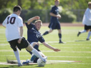 Carter Johnson, 14, of Skyview High School slide tackles Cameron Watson, 10, of Central Kitsap in the boys 4A State Soccer Championship game Saturday May 26, 2012 at Carl Sparks Stadium in Puyallup, Washington. Skyview beat Central Kitsap 3-2.