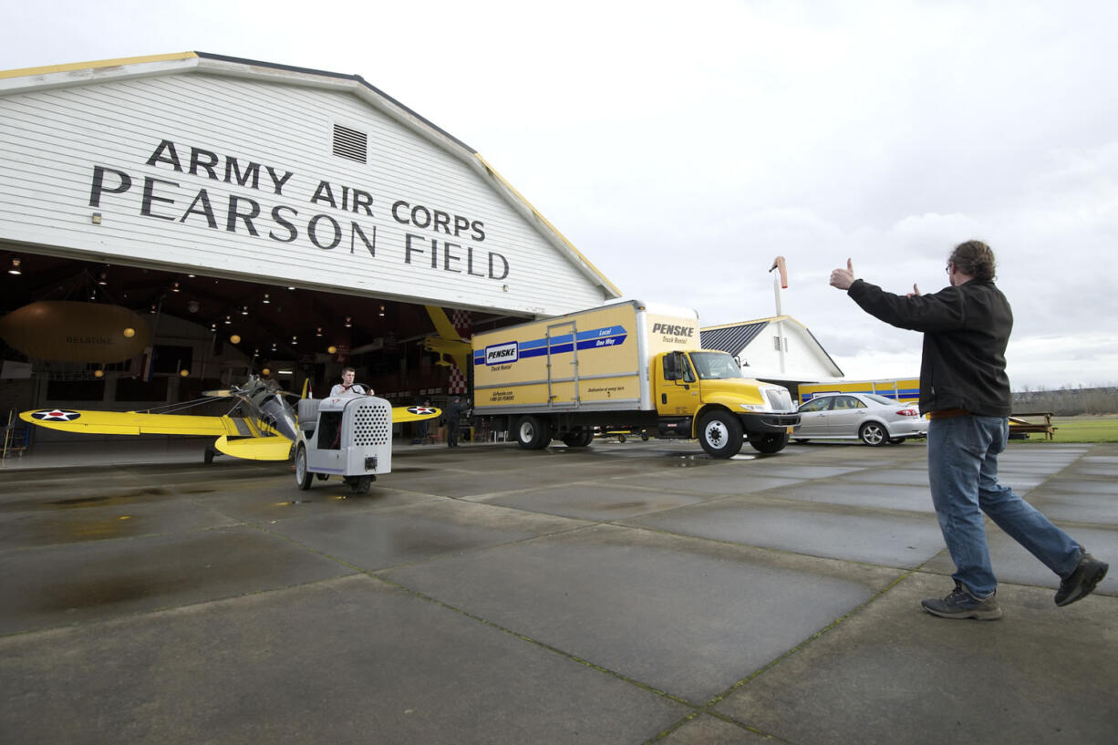 Joshua Staley, right, an A&amp;P technician and event staff supervisor, helps direct Tom Sturdy, also an event staff supervisor, as he moves a 1941 U.S.