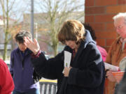 Esther Short: Robbie Moore, president of the local Aglow International group, extends her hand while she prays on Feb. 16 near the Clark County Courthouse flag pole.