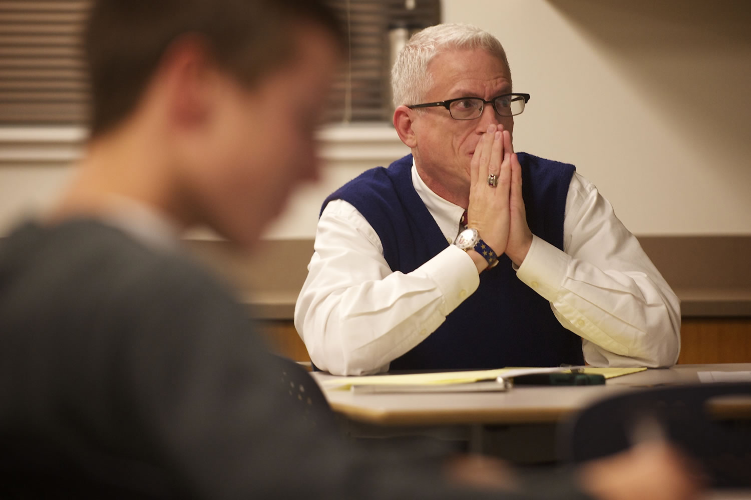 Dave Kosloski, director of speech and debate at Clark College, listens to the presidential debate with his debate team students Monday.