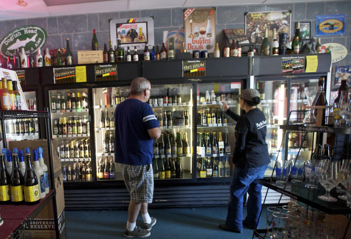 By The Bottle owner Arlene Nunez, right, helps Lyle Stoudt, of Vancouver, pick out a birthday gift for his son-in-law.