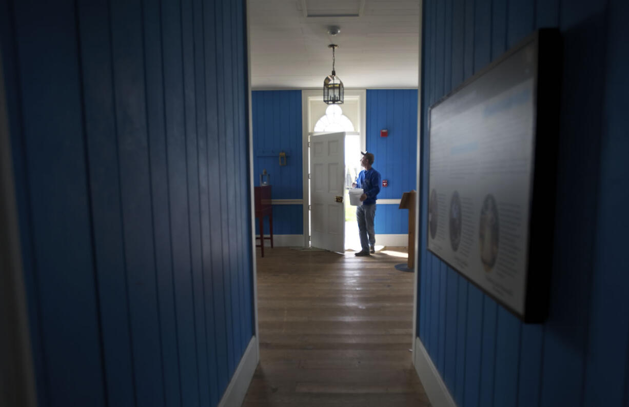 Viktor Chekota checks his handy work after painting the front door of the Counting House at Fort Vancouver National Historic Site.