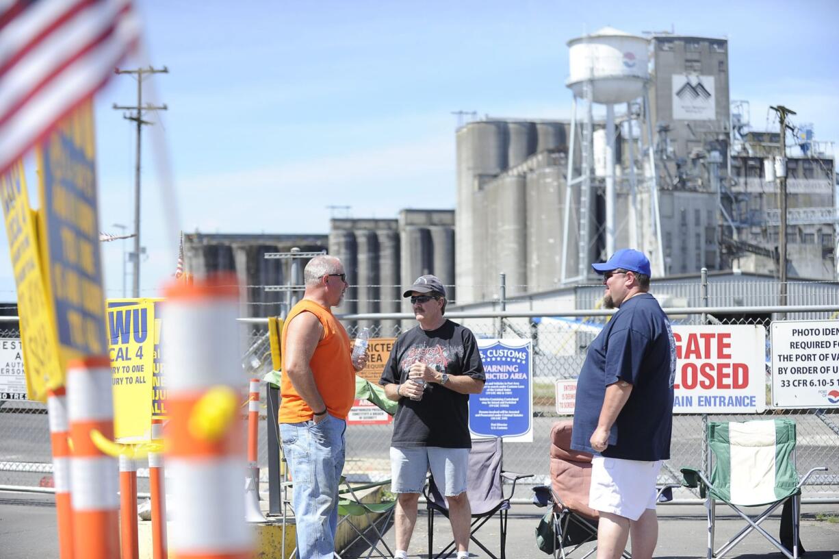 International Longshore and Warehouse Union members, from left, John Seidl, Bob Poppe and Shawn Unger picket June 6 outside the United Grain terminal at the Port of Vancouver. Poppe and Unger are members of Local 4, while Seidl is a member of Local 21. The union has maintained a picket at the port since its members were locked out of United Grain on Feb.