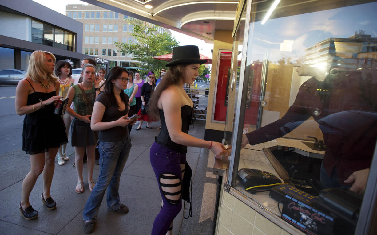 Kiggins Theatre owner Dan Wyatt sells a &quot;Moulin Rouge&quot; movie ticket to 17-year-old Lisa Stangler -- who's clearly ready for the pre-show costume contest. Because the historic Kiggins is &quot;loved by all but visited by few,&quot; Wyatt is trying to build a faithful following by featuring trivia quizzes, costume contests and as much audience participation as possible.