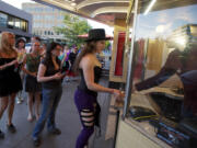 Kiggins Theatre owner Dan Wyatt sells a &quot;Moulin Rouge&quot; movie ticket to 17-year-old Lisa Stangler -- who's clearly ready for the pre-show costume contest. Because the historic Kiggins is &quot;loved by all but visited by few,&quot; Wyatt is trying to build a faithful following by featuring trivia quizzes, costume contests and as much audience participation as possible.