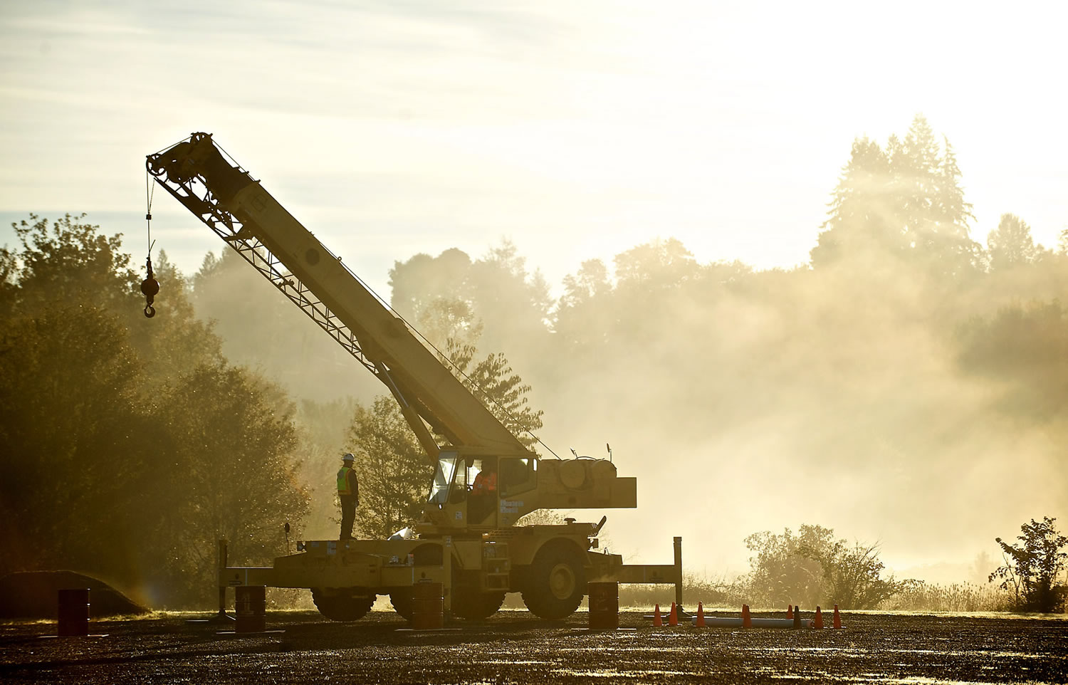 Examiner Alex Faris sits in the cab of a crane while an instructor stands nearby.