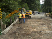 Construction crews prepare for the removal of the Cougar Creek Bridge along Washougal River Road on Thursday.