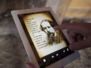 Brett Oppegaard uses the Fort Vancouver mobile app to link to Charles Dickens' &quot;A Tale of Two Cities&quot; in a Kanaka Village cabin just west of the reconstructed stockade.