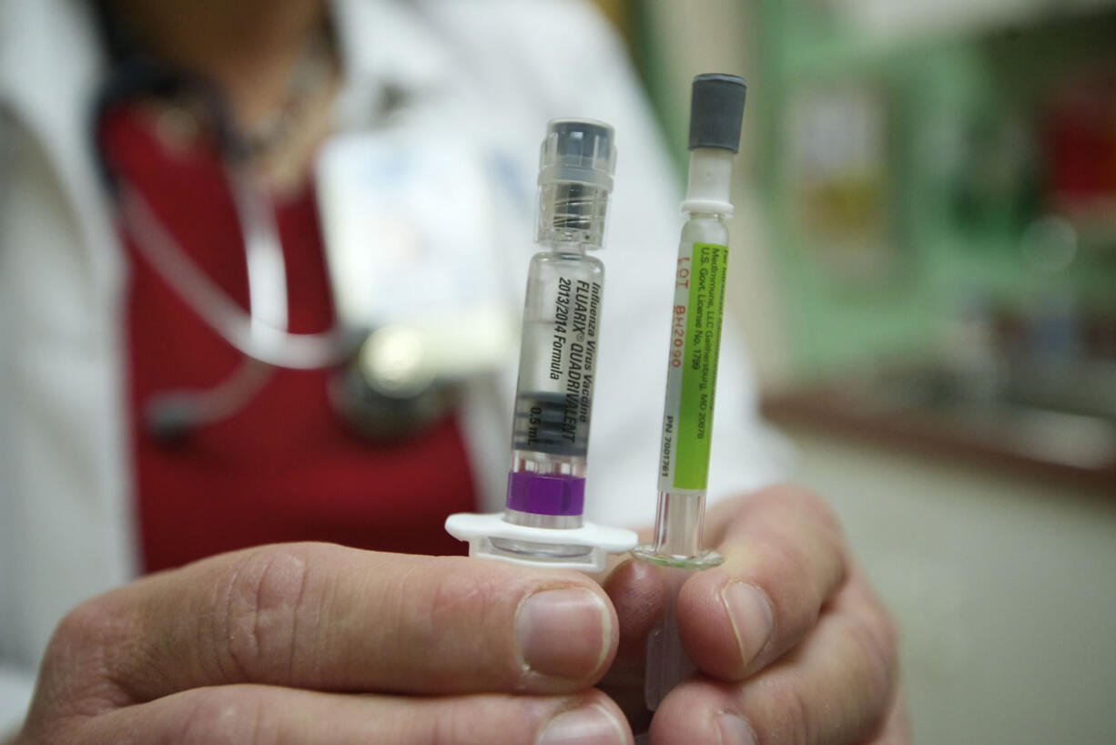 Lynnette Pickup, a nurse manager at Sea Mar Community Health Center, displays a new flu vaccine offered at the Vancouver clinic Friday. The quadrivalent vaccine protects against two strains of influenza A and two strains of influenza B.