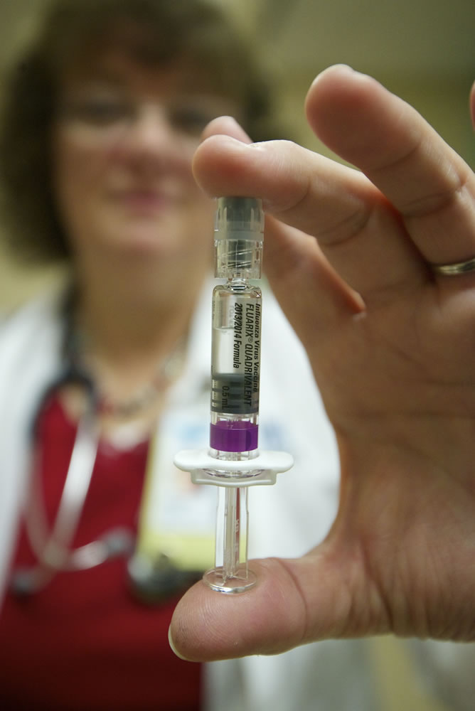 Lynnette Pickup, a nurse manager at Sea Mar Community Health Center, displays a new flu vaccine offered at the Vancouver clinic Friday. The quadrivalent vaccine protects against two strains of influenza A and two strains of influenza B.