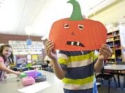 Hayden Crouse, 5, shows off a paper jack-o'-lantern he crafted in Laura Tomberlin's classroom on Oct. 22 at La Center Elementary School.