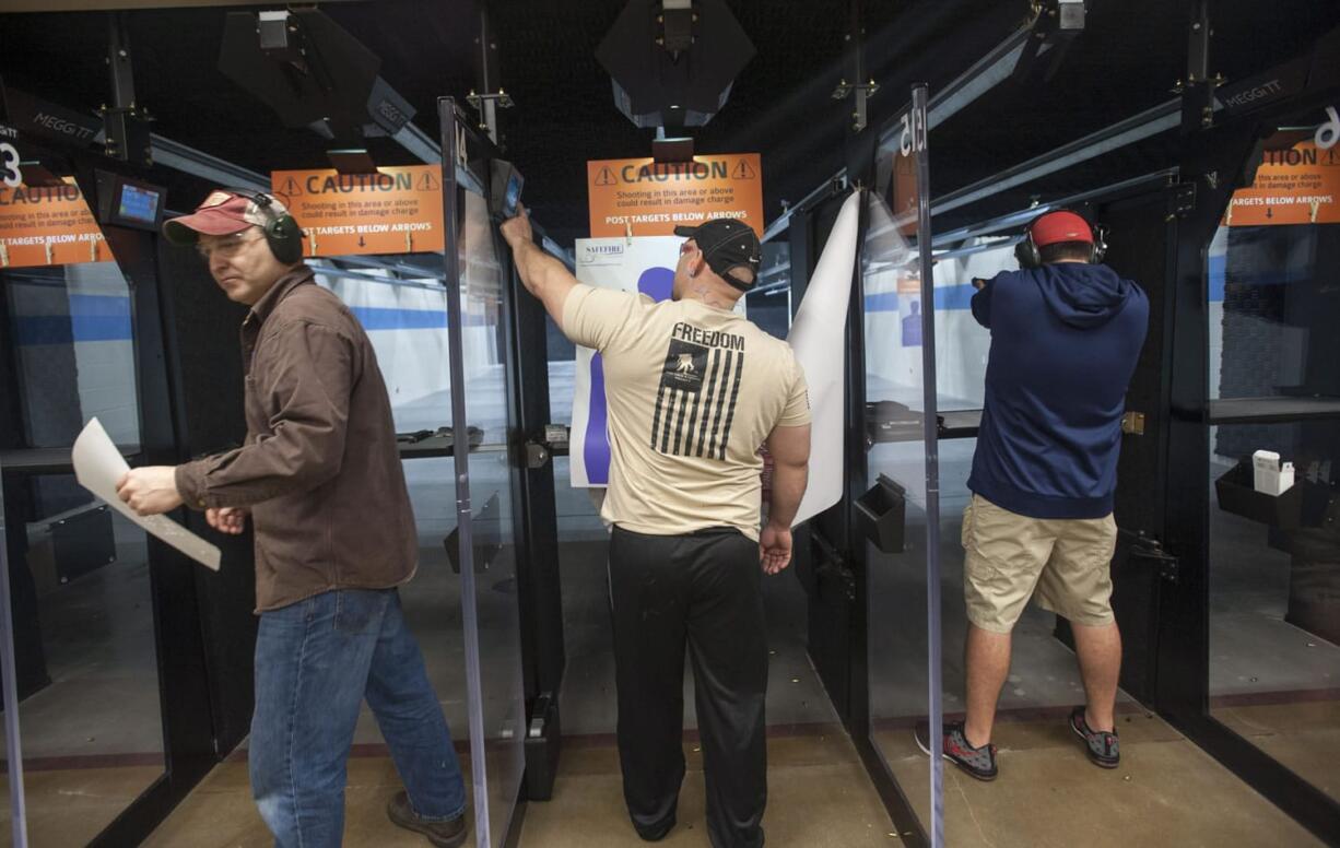 Tim Norneen, left, and Cory Gilday, center, try out the new SafeFire Indoor Shooting Range in Camas, which opened Tuesday.