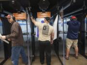 Tim Norneen, left, and Cory Gilday, center, try out the new SafeFire Indoor Shooting Range in Camas, which opened Tuesday.