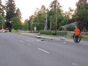 A Clark Public Utilities worker rolls up power line that fell Friday after a car sheared off two light poles on East Mill Plain Boulevard.