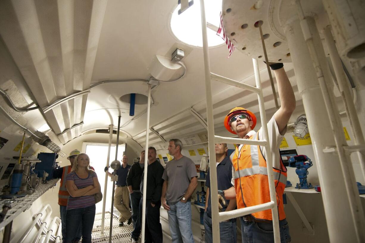 Justin Piper, right, a BNSF hazmat manager, provides training to firefighters and other safety personnel inside a tank car designed for training purposes Tuesday in Vancouver.