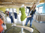 Volunteer Blakeley Buratto prepares a mannequin for a display at B. Divine clothing boutique.