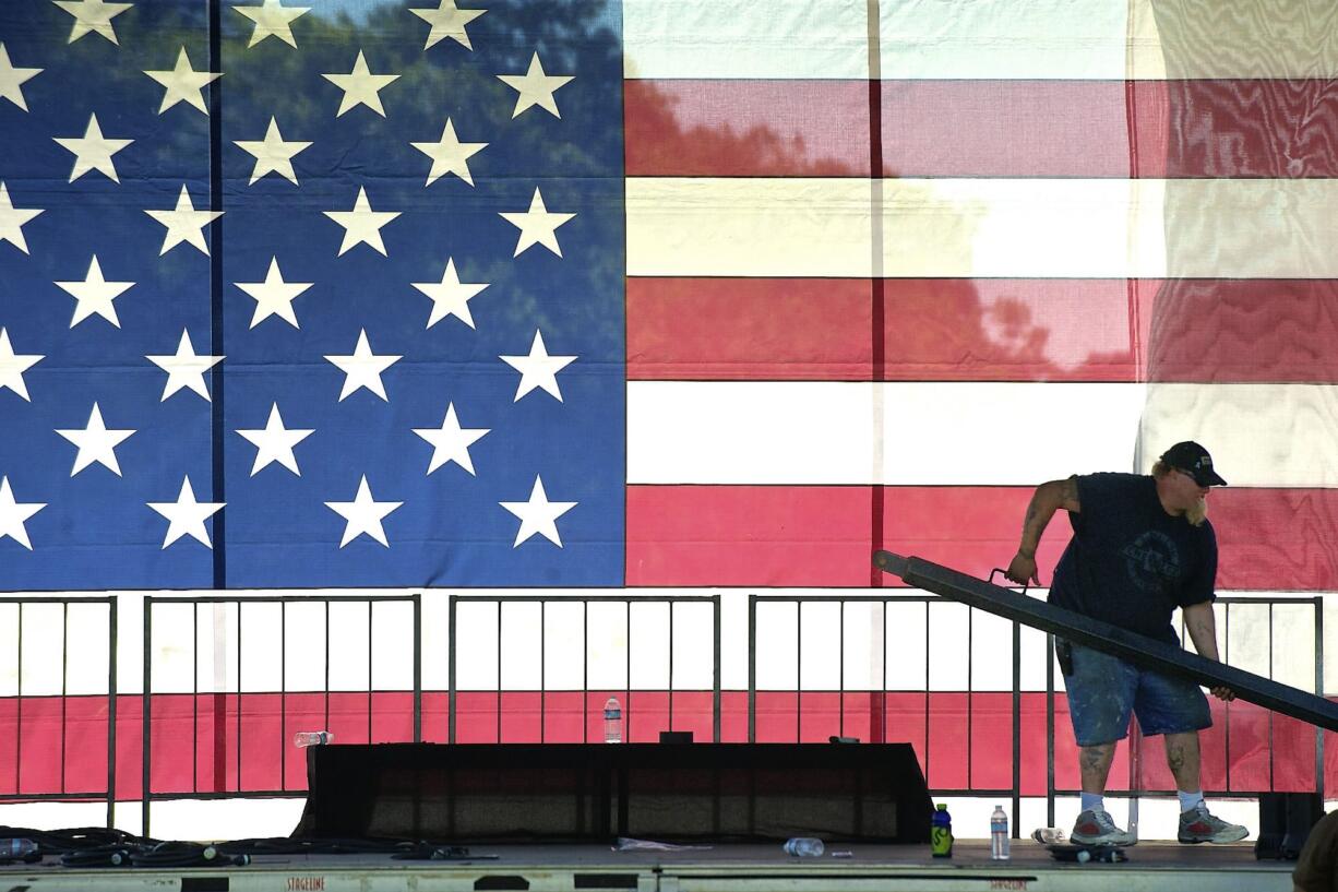 Eric Newton, a sound stage technician with Stages Northwest, lifts a support beam while helping to construct the main stage Tuesday for the upcoming Fourth of July fireworks show.