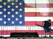 Eric Newton, a sound stage technician with Stages Northwest, lifts a support beam while helping to construct the main stage Tuesday for the upcoming Fourth of July fireworks show.