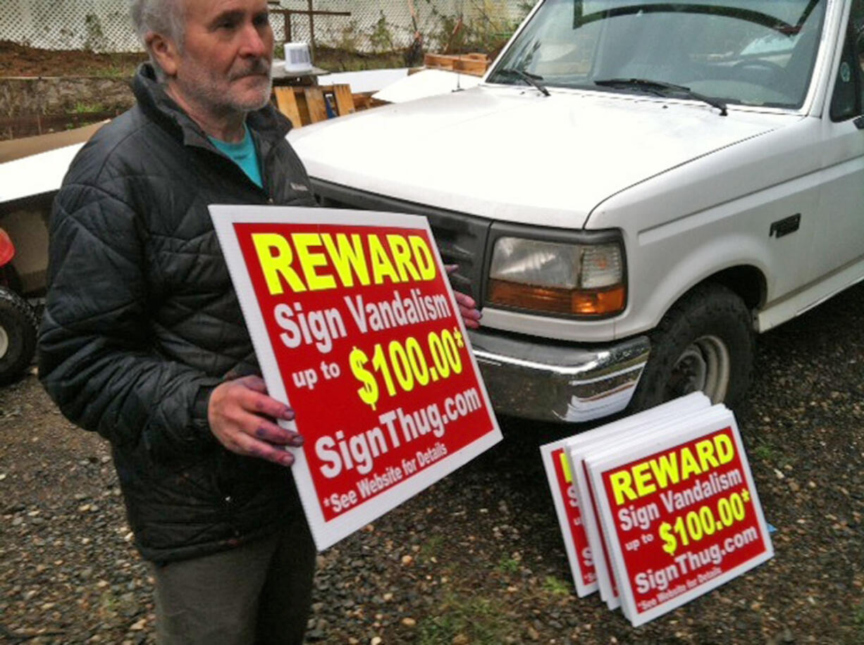 Tom Edwards of Woodland printing company Yardsign.biz holds a sign he printed for a group called Sign Thug, which is targeting political sign vandalism.