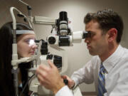 Brett Richardson examines Marina Kondratyuk, 15, during a routine eye exam at the Richardson Eye and Contact Lens Clinic in Vancouver. Below, Todd Richardson uses a new scanning laser machine to view the retina image and other parts of an eye.