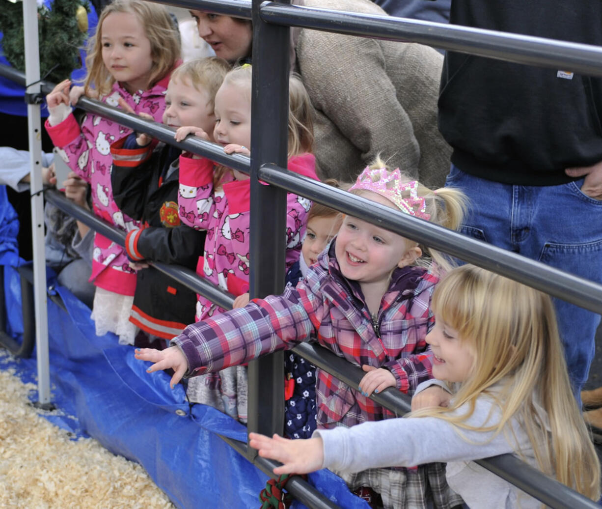 Children, including 3-year-old Andria Fuhrer, second from right, call for the reindeer Sunday afternoon at the Christmas block party on Main Street in Vancouver. Two reindeer, Blitzen and Candy, were visiting from the Spokane area.