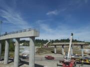 Crews move a crane, in pieces, into place near southbound Interstate 5 in preparation for this weekend's girder installation.