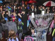 Chabad Jewish Center Rabbi Shmulik Greenberg, center, leads a group of children in a prayer next to an ice sculpture of a menorah at a Hanukkah celebration and menorah lighting Sunday in Esther Short Park in Vancouver.