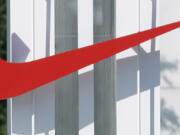 The red Nike swoosh marks the entrance to the company's headquarters campus in Beaverton, Ore.