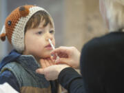 Felix North, 3, gets a flu-mist immunization during a free flu vaccine clinic in 2015 at Legacy Salmon Creek Medical Center in Vancouver. Felix and his mom, Ewa North, were immunized to protect younger brother, 4-month-old Emmett, who is too young to be immunized.