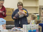 Crestline Elementary second-grade teacher Katie Van Ness receives a bag of snacks from her students, Maddie Burris, 7, and brother Devon Burris, 7, as she readies her new classroom at Columbia Valley Elementary.