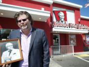 Scott Dickinson, former owner of eight area Kentucky Fried Chicken restaurants, holds a black-and- white photo of KFC founder Col. Harland Sanders. Dickinson is liquidating his KFC business, which operated under the name Dickinson Northwest Inc. Two of the Vancouver restaurants, including the one shown here at 1203 N.E.