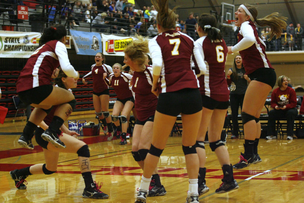 Prairie players celebrate the winning point in game two of their 3A volleyball state championship against North Thurston.